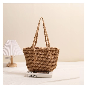 Detail of handcrafted brown cotton rope weave texture and braided handles on beach bag