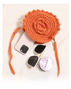 Detail showing internal capacity of the orange hand-woven round bag with daily items