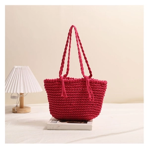Detailed texture of rose pink cotton rope woven shoulder bag with long handles and tassels