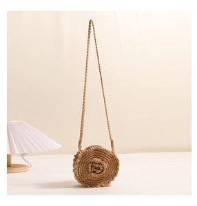 Close-up of a handmade woven straw bag featuring a decorative 3D rose flower detail