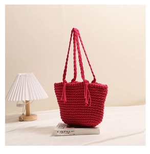 Detail of handmade fuchsia cotton knit tote bag with woven handles and fringe accents