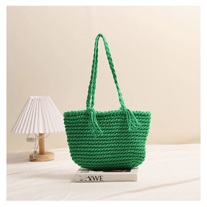 Detail of green woven cotton tote bag featuring handmade tassel accents and long straps