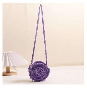 Close-up of purple hand-woven crochet bag featuring 3D floral accents and golden hooks