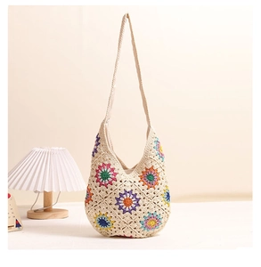 Detail of colorful granny square flower patterns on beige crochet woven shoulder bag