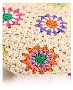 Macro detail of hand-crocheted bohemian floral bag with colorful sunflower patterns