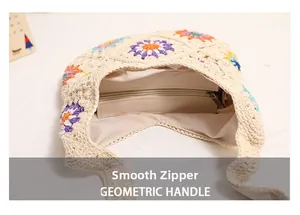 Close-up of smooth metal zipper and colorful floral knit patterns on a woven bag