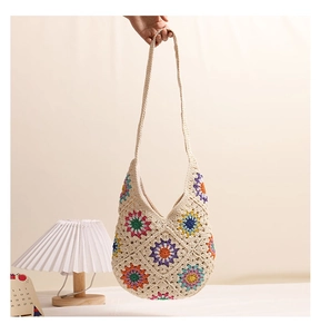 Close-up of hand-woven crochet shoulder bag with colorful floral granny square patterns