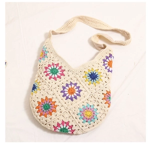 Macro detail of bohemian crochet tote with colorful daisy flower embroidery patterns