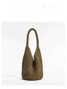 Detailed close-up of retro hollow woven pattern on brown straw shoulder bag