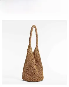 Detailed macro view of the hollow diamond mesh weave on a brown straw beach bag