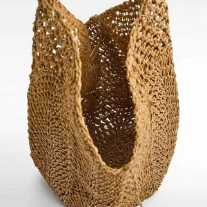 Handwoven caramel straw tote bag featuring hollow wave pattern for beach vacations
