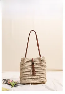 Close-up of woven cotton tote bag featuring elegant tassels and wooden bead details