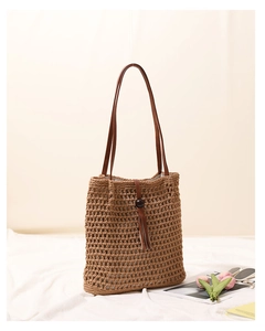 Close-up of hand-woven cotton shoulder bag featuring tassel and wooden bead detail