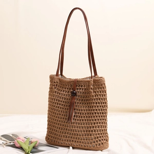 Handwoven khaki straw tote bag with leather straps, fringe tassels, and wooden beads
