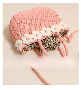 Close-up of pink straw bag with floral crochet edge and polka dot drawstring lining