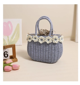 Detail of light blue straw bag with white crochet flowers and polka dot drawstring lining