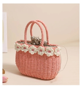 Close-up of pink straw bag with crochet flowers and black polka dot drawstring lining