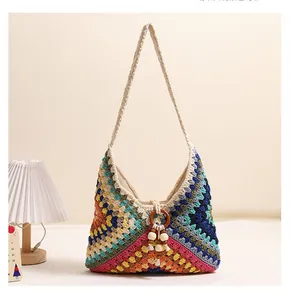 Detail of colorful crochet shoulder bag with geometric blocks and wooden bead tassel