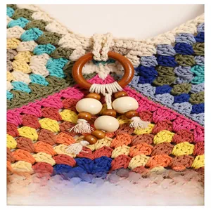 Detail of colorful crochet shoulder bag with wooden ring and ivory tassel charm