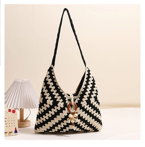 Detail of hand-woven crochet bag with zigzag pattern and decorative wooden bead tassels