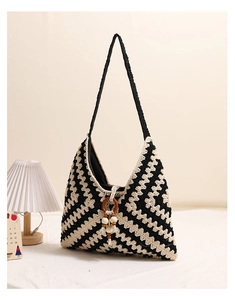 Detail of hand-woven zigzag pattern cotton bag with wooden ring and cream tassel