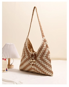 Detail of bohemian crochet tote with beige wavy knit texture and wooden ring charm