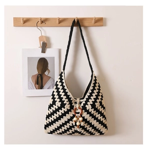 Detail of bohemian knit shoulder bag with zig-zag pattern and wooden bead tassels