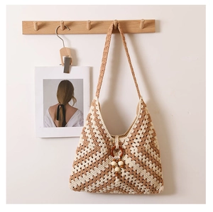 Detail of bohemian woven shoulder bag featuring wooden ring and beige bead accents