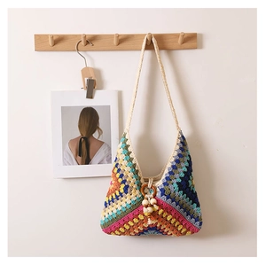 Detail of boho crochet tote with colorful geometric patterns, wooden beads and fringe
