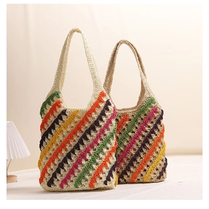 Close-up of handmade chevron striped straw tote bags featuring colorful crochet patterns