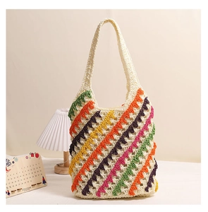 Detail view of a handmade crochet tote bag featuring colorful striped knit patterns