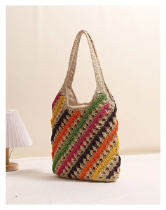 Detail of colorful zigzag stripes and crochet texture on a beige straw beach tote bag