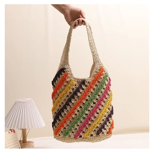 Close-up of colorful striped straw tote bag with boho woven texture and soft handles