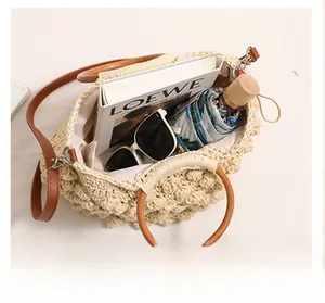 Vue détaillée de la capacité du sac en paille avec poignée en bois et bandoulière