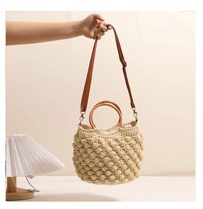 Détail du tissage popcorn sur sac en crochet beige avec poignée ronde en bois