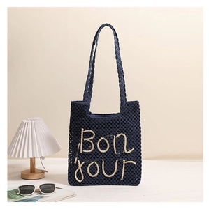 Detailed macro view of navy blue woven tote bag featuring Bonjour letter embroidery