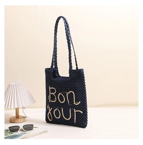 Detail of navy blue woven tote bag with Bonjour embroidery and hollow mesh texture