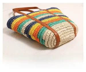 Close-up of colorful striped straw tote bag featuring leather handles and large capacity