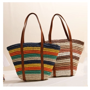 Close-up of colorful striped straw tote bags with premium brown leather shoulder straps