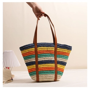 Detailed texture of colorful striped straw tote bag with brown leather handles on display