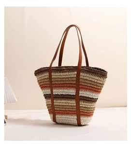 Close-up of multicolor striped straw tote bag with brown leather handles for beach