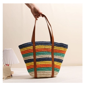 Detailed view of vibrant multi-color woven straw stripes and brown leather handle