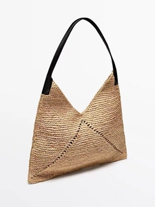 Detail of raffia woven triangle tote with premium black leather shoulder strap