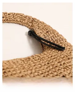 Close-up of natural straw weave texture and black rope handle detail on the summer beach bag