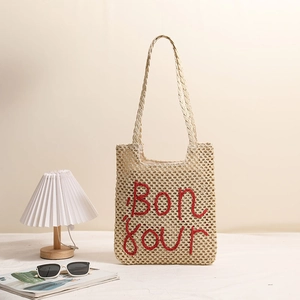 Beige straw tote bag with red Bonjour embroidery and hollow weave for beach vacation