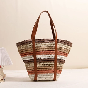 Colorful striped straw tote bag with brown leather handles for summer beach vacations