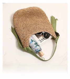 Vue détaillée d'un sac en paille montrant sa grande capacité avec des accessoires