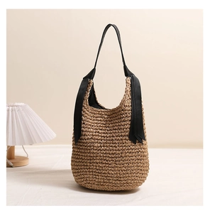 Détail d'un sac cabas en paille tissé main avec grande capacité et rubans noirs aux anses