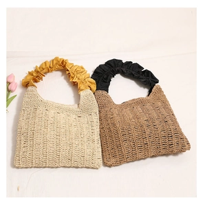 Detail of straw woven tote bags with ruffled silk handles in beige and brown colors