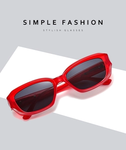 Close-up of red transparent rectangular sunglasses on a white platform
